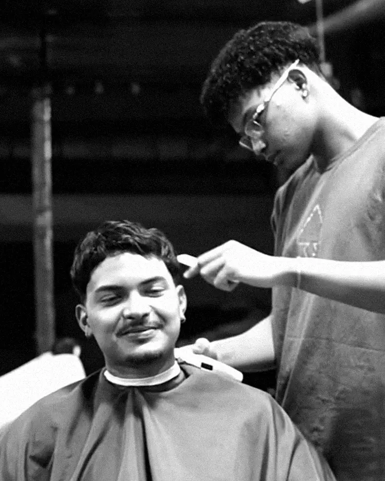 Barbeiro trabalhando no corte de um cliente